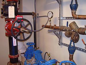 View of a plumbing piping system attached to a wall at a client facility