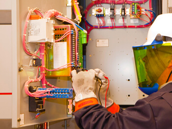 IKM electrician working on wires inside of an electrical pull box