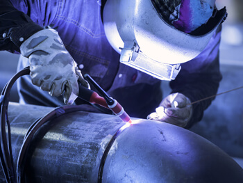 IKM welder working on a pipe fabrication project