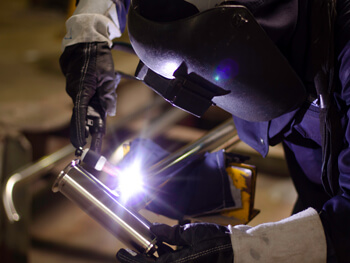 IKM welder working on a metal fabrication project